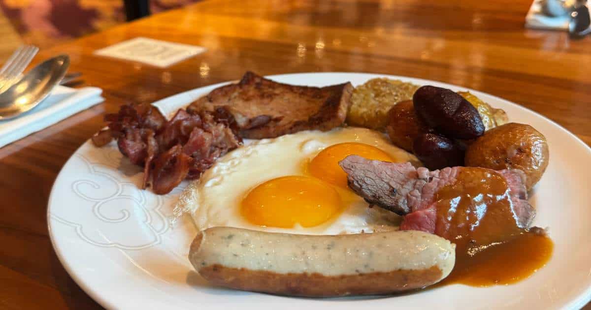 Western breakfast buffet plate with eggs, bacon, sausage, and roast beef at Disney Explorers Lodge