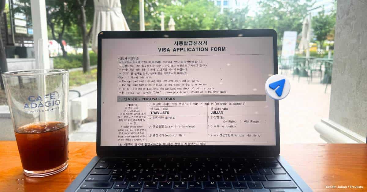 Filling out a Korean visa application form displayed on a laptop screen at a Paris Baguette cafe